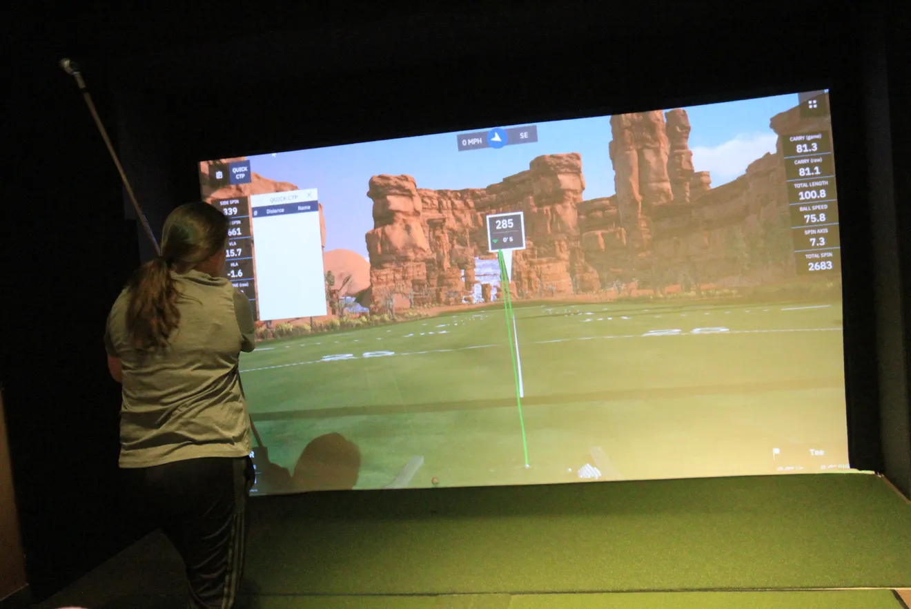 Golfer playing on a GSPro simulator bay